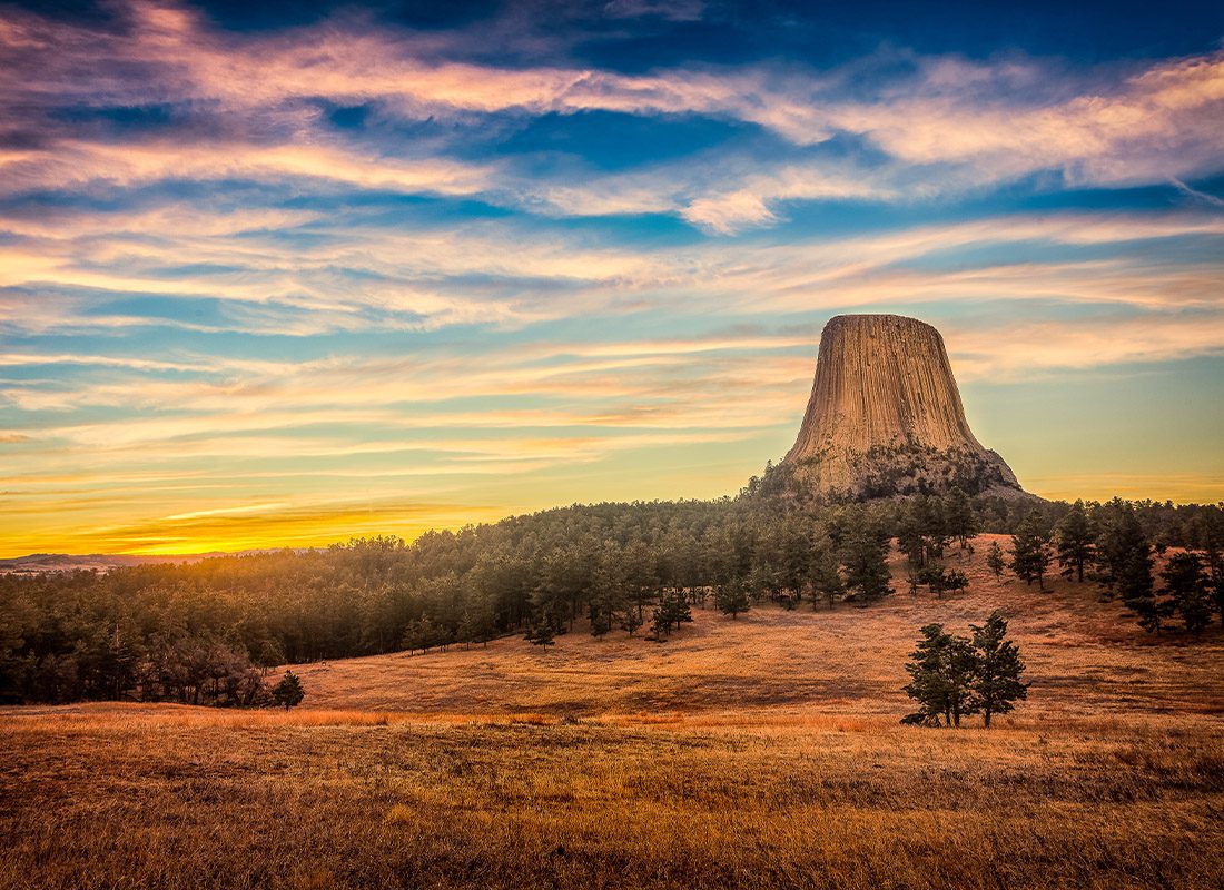 About Our Agency - Devils Tower from Across the Field at Dusk